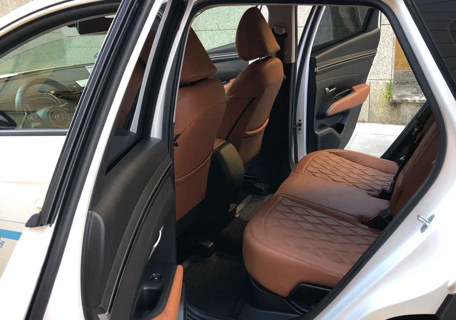 Vista en detalle de la parte trasera de un coche blanco marca Hyundai con asientos de cuero marrones